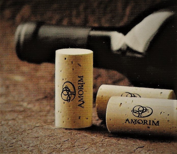 Amorim natural corks beside a wine bottle
