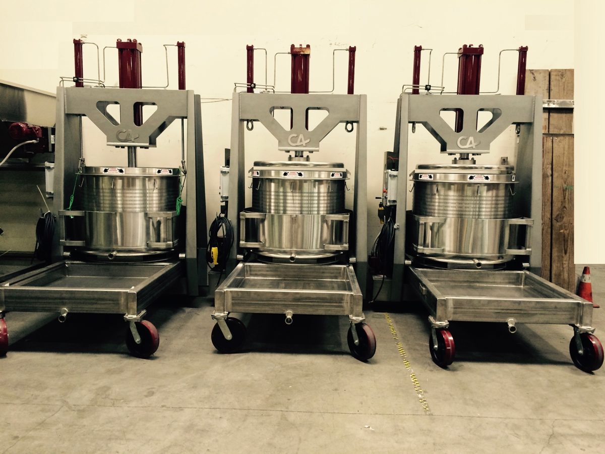 Three Carlsen & Associates stainless basket presses on casters